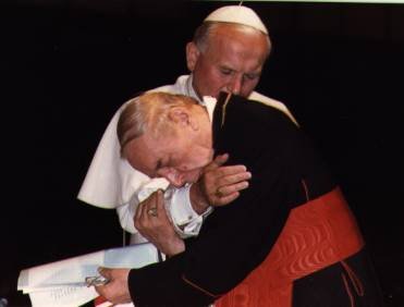 Papież Jan Paweł II obejmuje pochylonego przed nim kardynała