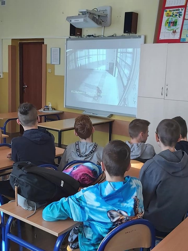 Uczniowie oglądają prezentację multimedialną przygotowaną przez policjantów